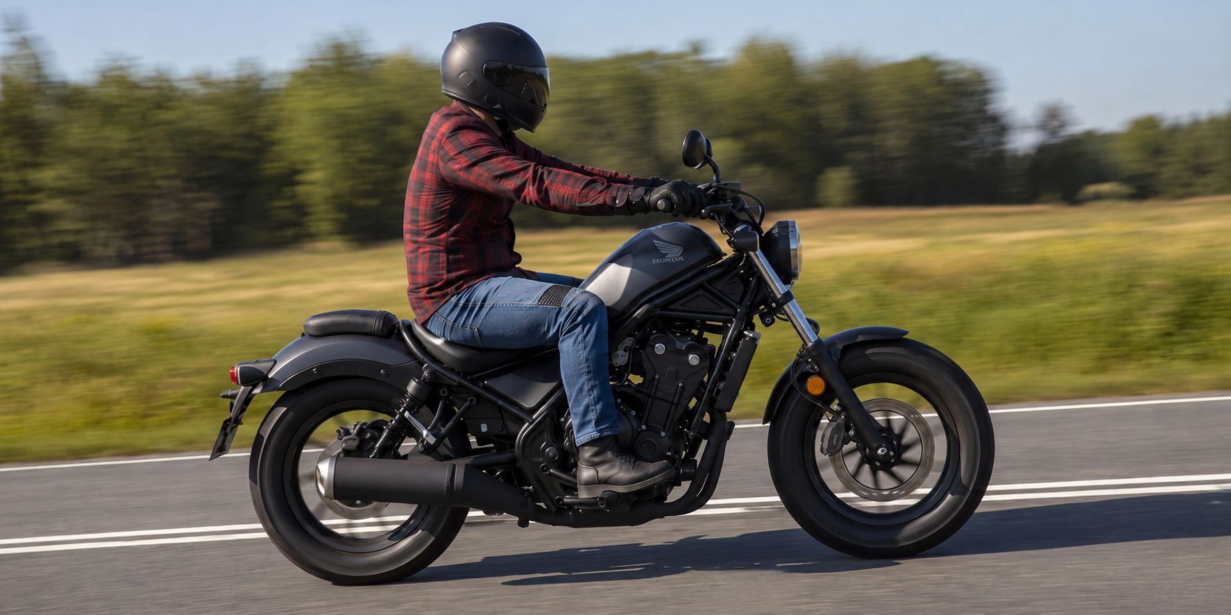Motorkář v kevlarových džínách a moto košili při jízdě na motorce