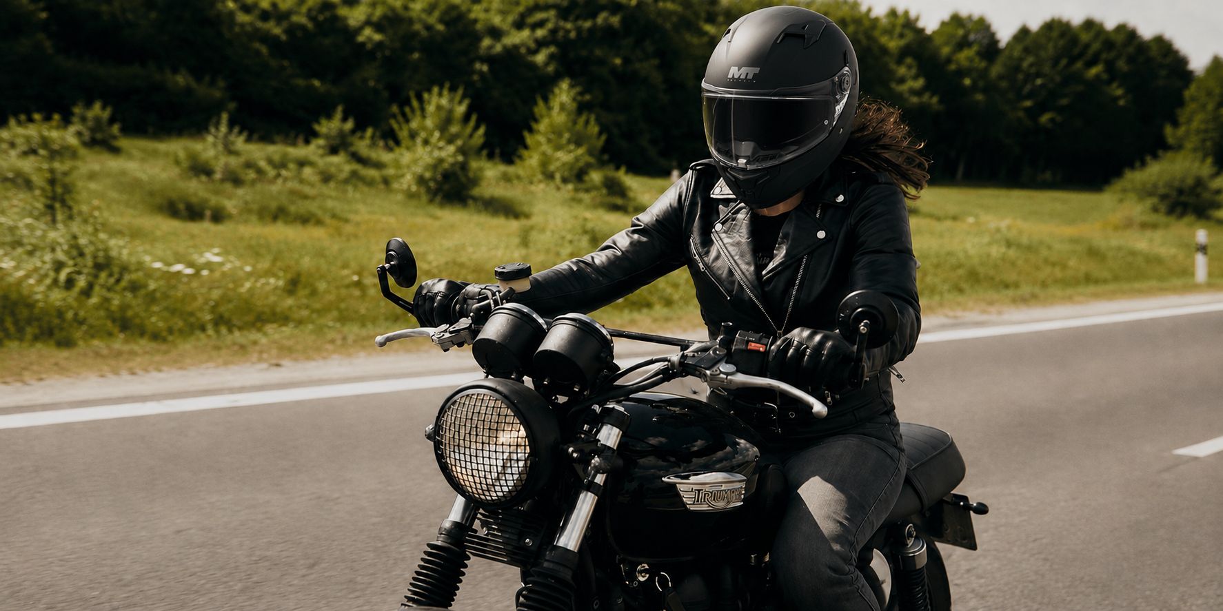 Motorkářka v černé kožené bundě při jízdě