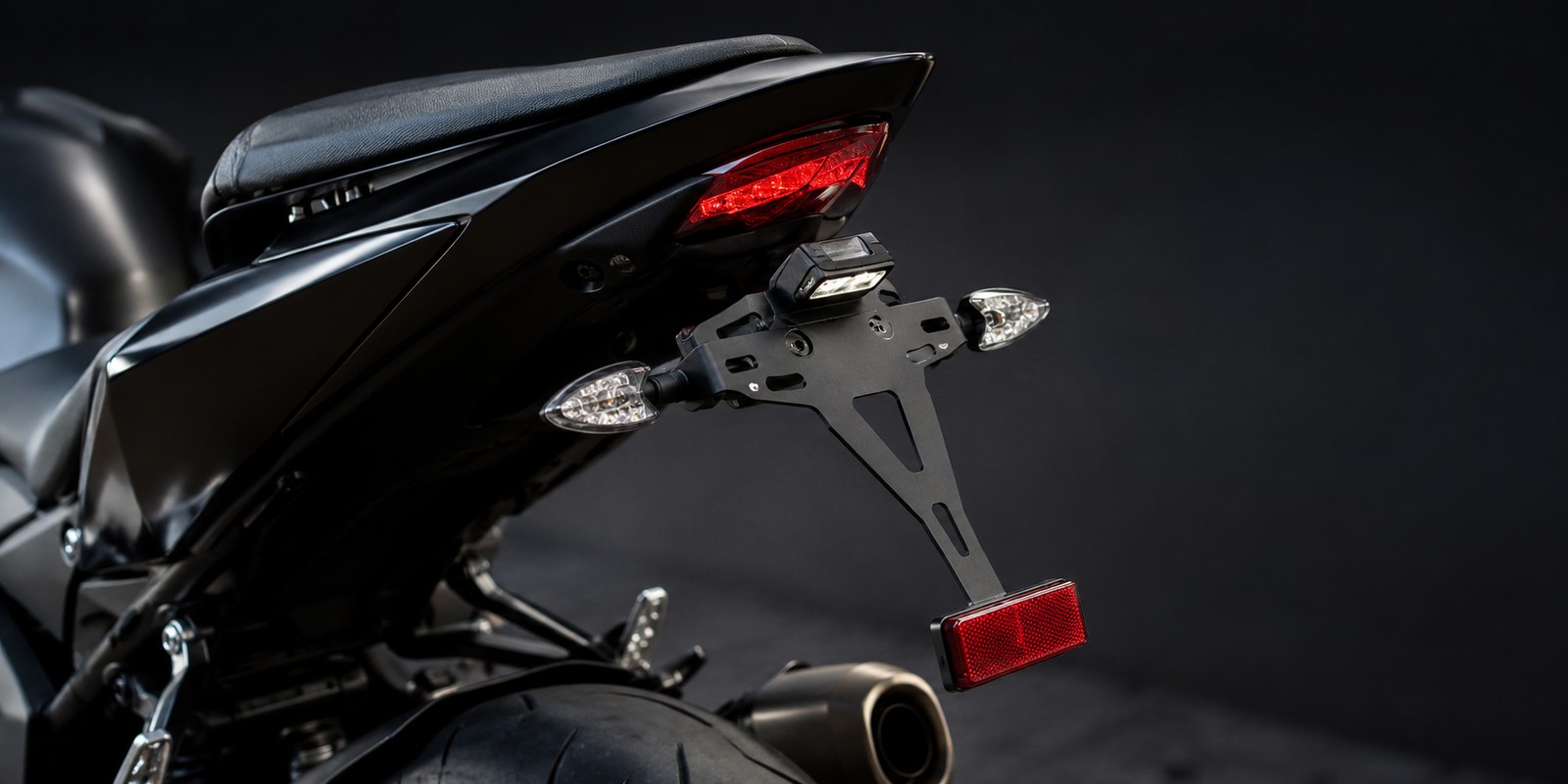 Detailný pohľad na nastaviteľný kovový držiak ŠPZ namontovaný na zadnej časti motocykla